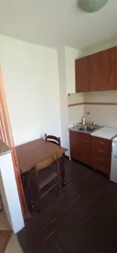 Manja kuhinja sa drvenim elementima i trpezarijskim stolom. - image 4