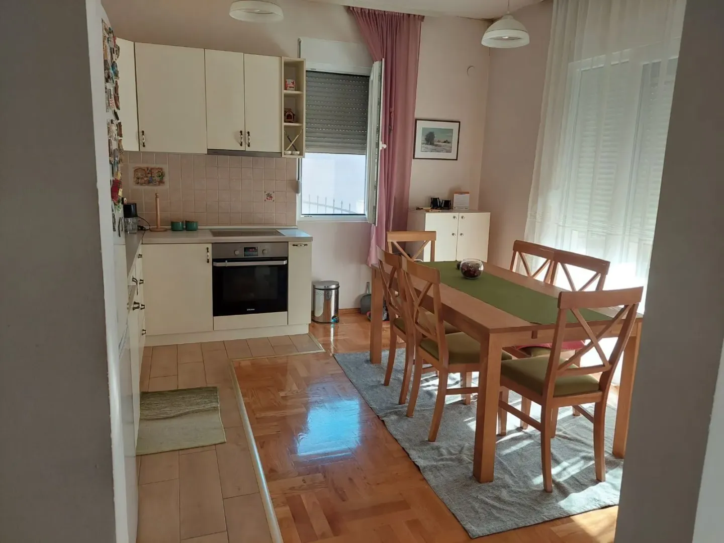 Bright kitchen and dining area with a wooden table and chairs.