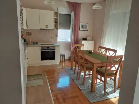 Bright kitchen and dining area with a wooden table and chairs. - image 17