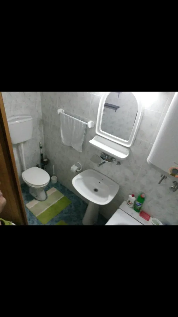 Manje kupatilo sa umivaonikom, wc šoljom i ogledalom.