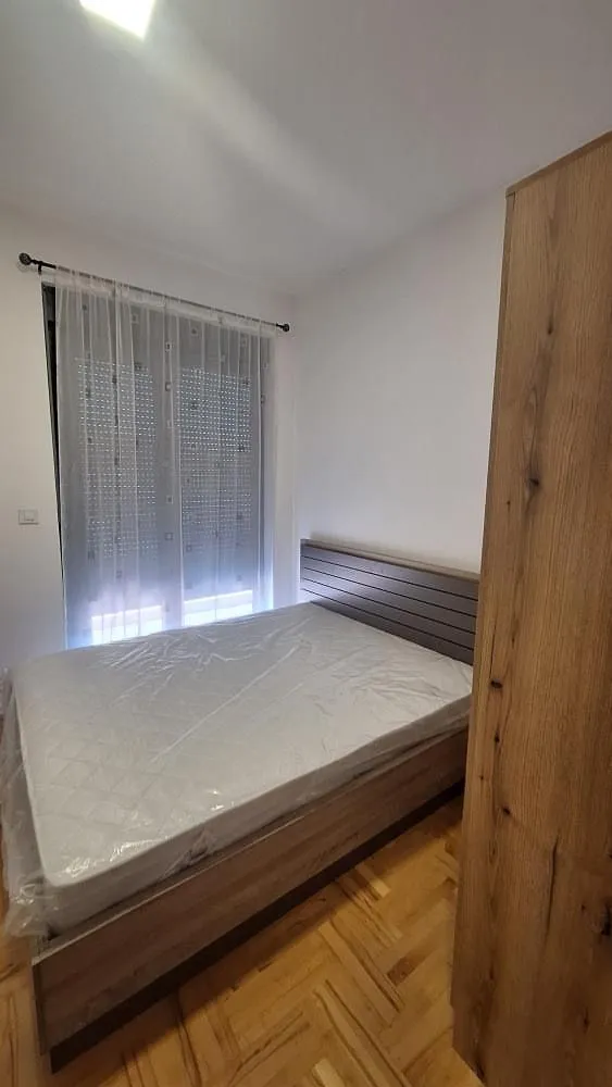 Bedroom with a double bed and a wooden wardrobe.