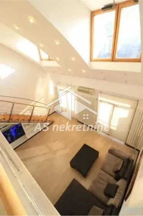High-angle view of the living room with a high ceiling and skylights.