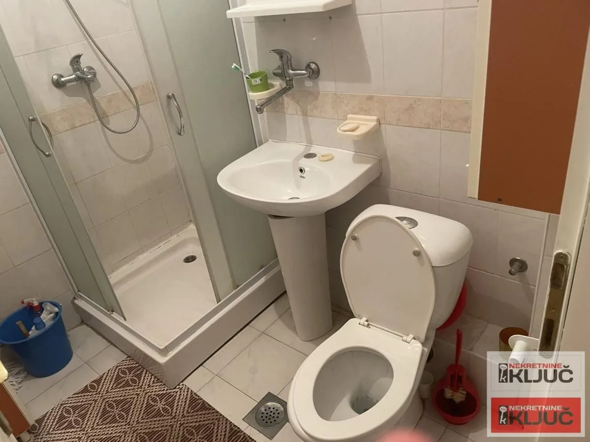 Kupatilo opremljeno tuš kabinom, umivaonikom i toaletom.