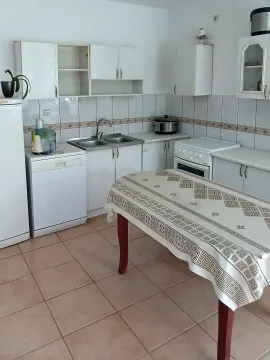 Older kitchen with a dining table and basic kitchen units. - image 7