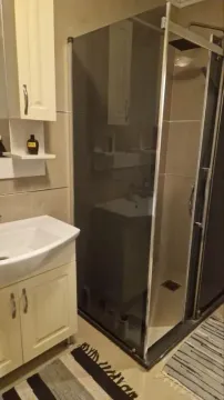 Bathroom equipped with a washbasin and a glass-door shower cabin. - image 7