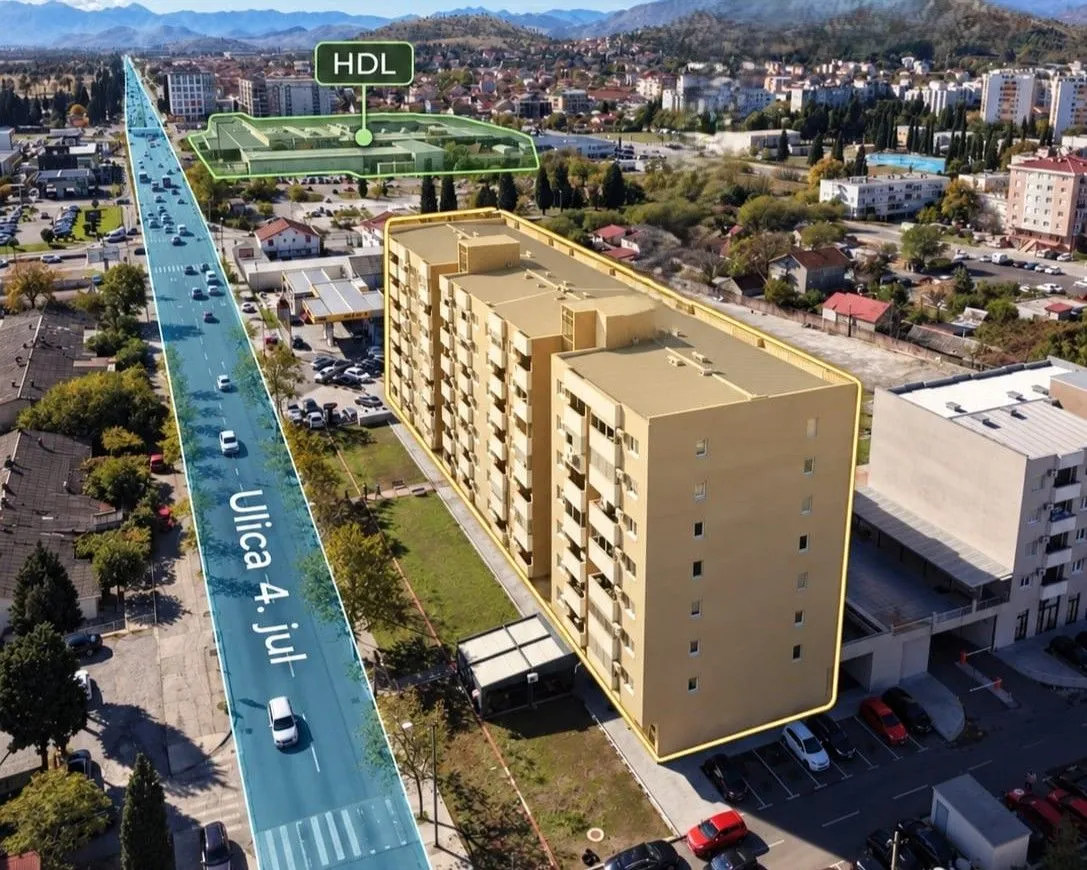 Pogled iz vazduha na stambenu zgradu sa okolnom infrastrukturom i saobraćajnicom.