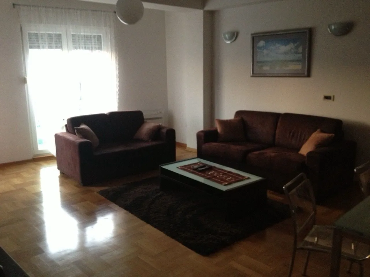 A living room with two brown sofas and a coffee table on a rug.