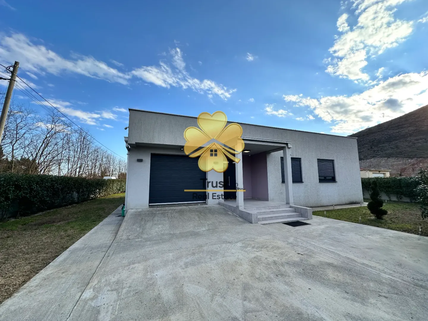 Exterior view of a single-story house with a garage and yard.