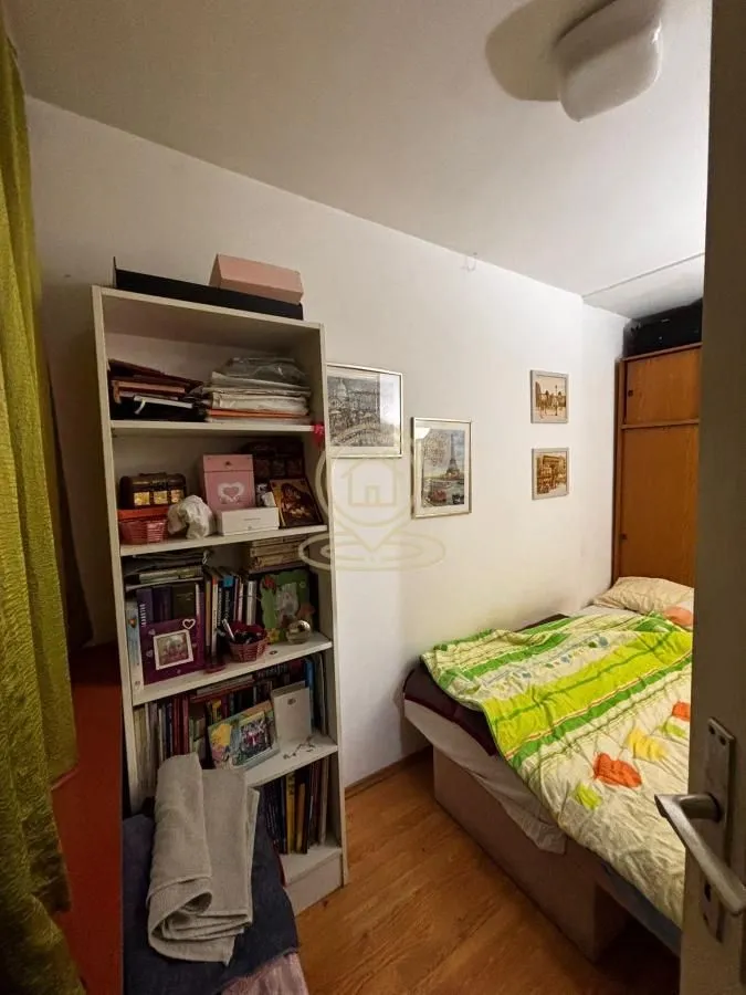 Smaller bedroom with a bed, wardrobe, and a bookshelf.