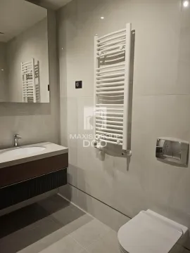 Modern bathroom equipped with a washbasin, toilet, and towel radiator. - image 15