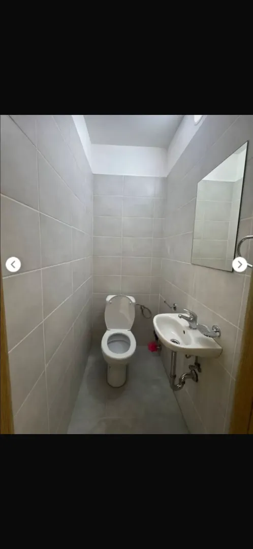 Smaller bathroom tiled with ceramic tiles featuring a toilet and a washbasin.