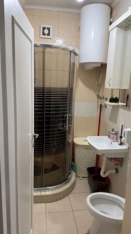 Manje kupatilo sa tuš kabinom, umivaonikom i wc šoljom.