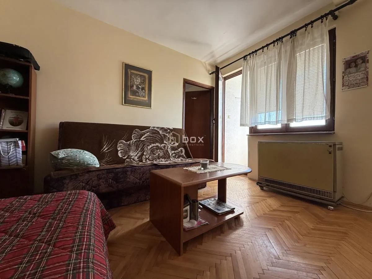 Dnevna soba sa kaučem, stočićem i izlazom na terasu.