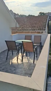 Terasa sa garniturom za sedenje i pogledom na krovove. - image 2