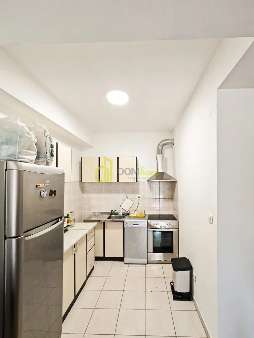 Small kitchen with white cabinets, refrigerator, and stove.