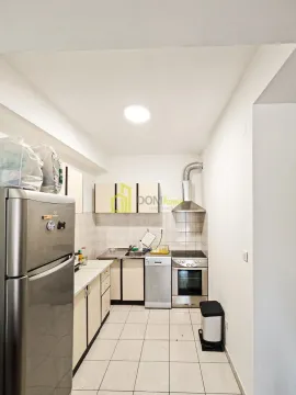 Small kitchen with white cabinets, refrigerator, and stove. - image 4