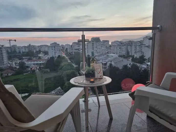 Furnished balcony with a table, chairs, and a city view.