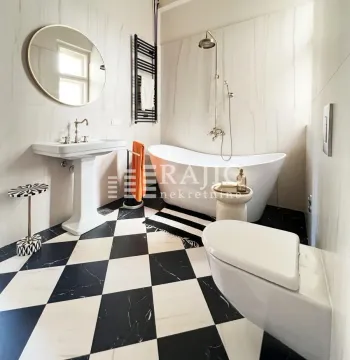 Modern bathroom with a bathtub and black and white flooring. - image 6