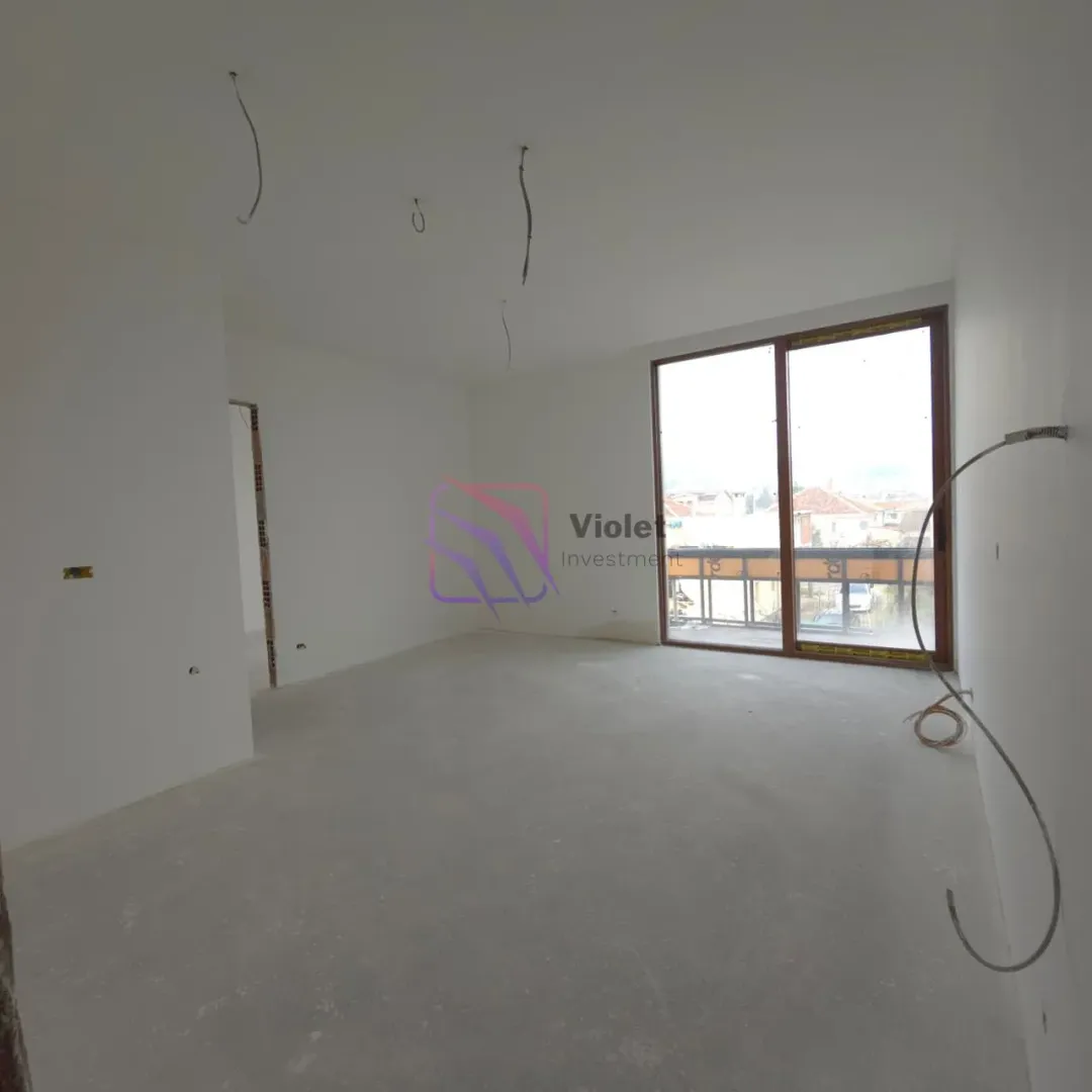 Empty room under construction with balcony doors and installed wiring.