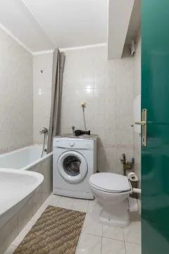 Kupatilo opremljeno kadom, umivaonikom, WC šoljom i veš mašinom. - image 8