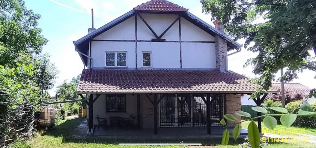 Pogled na zadnju stranu kuće sa natkrivenom terasom i dvorištem.