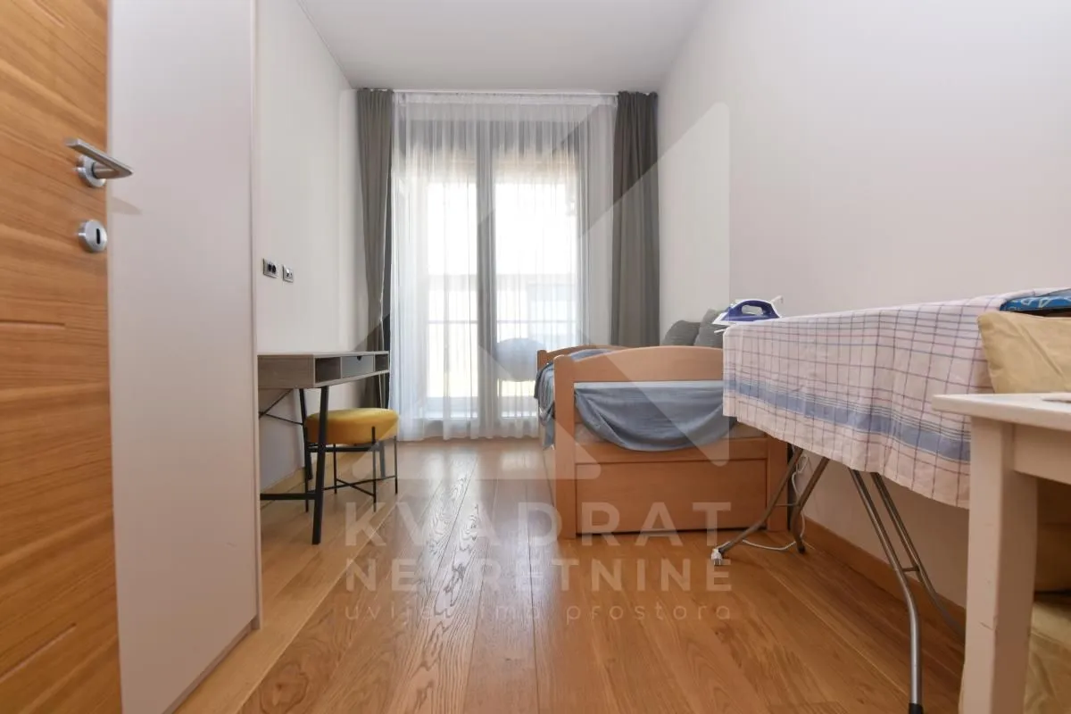 Smaller bedroom with a bed, desk, and access to the terrace.