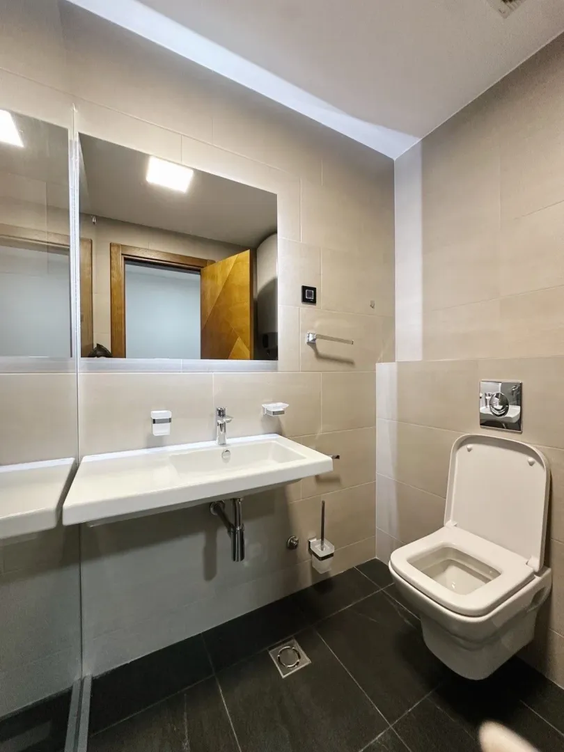 Modernly equipped bathroom with a washbasin and toilet.