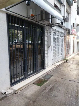 Exterior of a commercial space with metal security bars at the entrance. - image 4