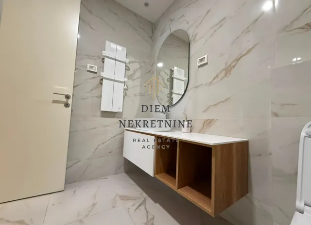Modern bathroom with a washbasin, mirror, and marble-pattern ceramic tiles.