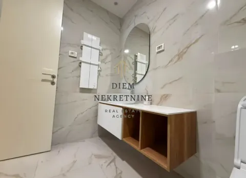 Modern bathroom with a washbasin, mirror, and marble-pattern ceramic tiles. - image 2