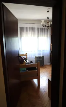 View from the hallway into a bedroom with a wooden bed and parquet flooring. - image 4