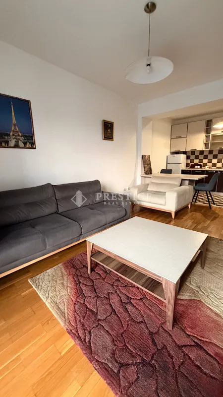 Dnevna soba sa garniturom i pogledom na kuhinju.