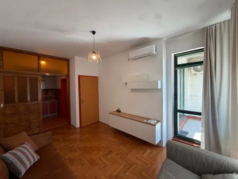 Living room with parquet flooring, furniture, and access to the terrace. - image 2