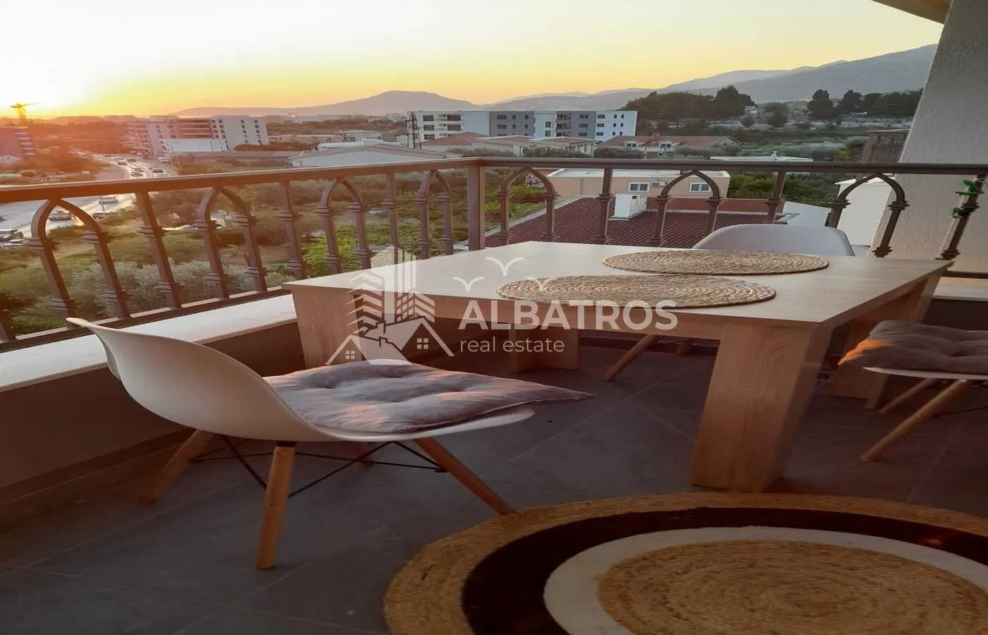 Furnished balcony with a dining table and city view.