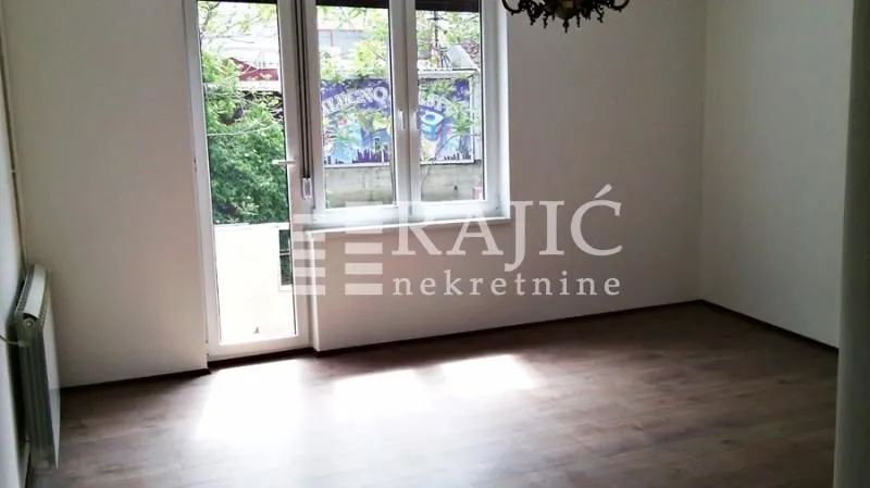 Empty room with laminate flooring and balcony access.