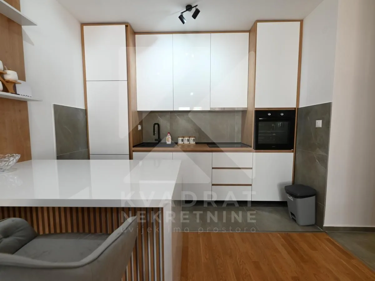 Modern kitchen with built-in appliances and white cabinetry.