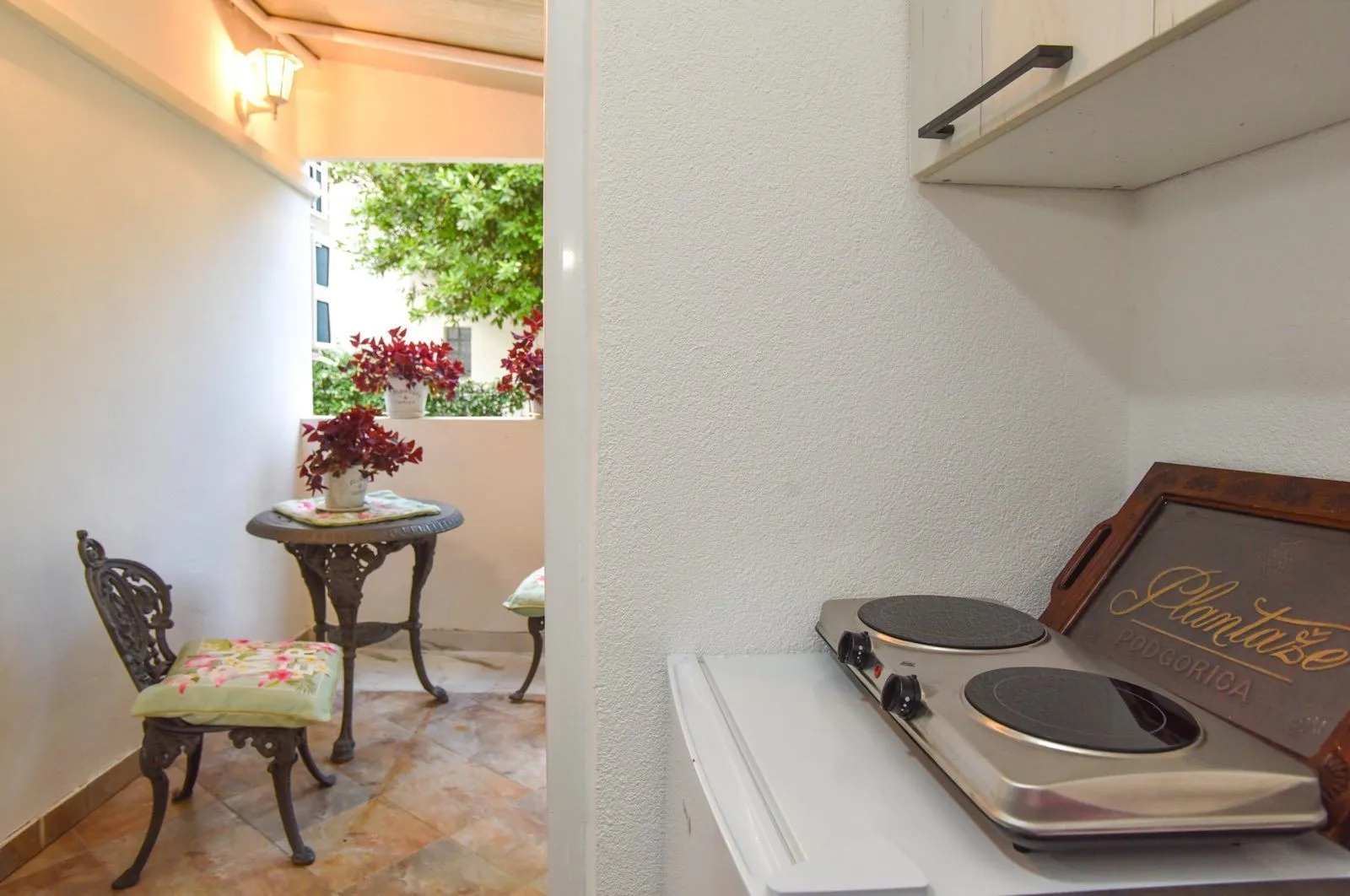 View from the kitchen onto a small balcony with a table and chairs.