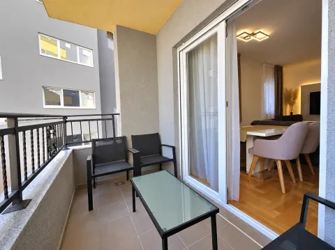Furnished balcony with outdoor seating and a view of the neighboring building. - image 9