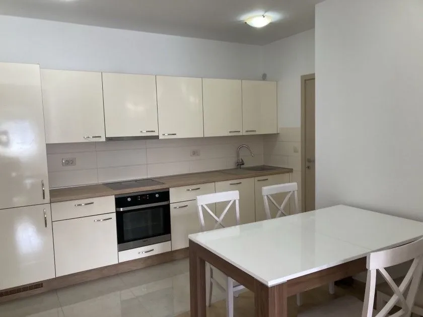 Modern kitchen with white cabinets and a dining table.