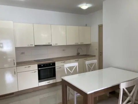 Modern kitchen with white cabinets and a dining table. - image 3