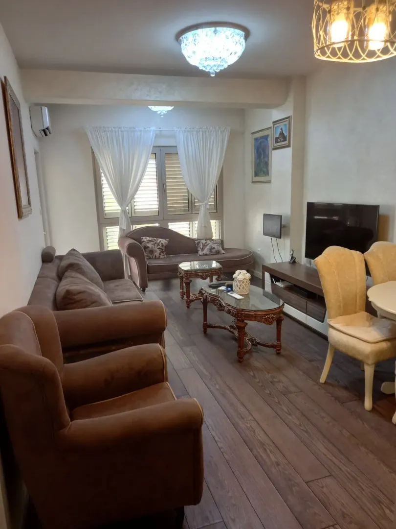 Living room with a sofa set, coffee table, and television.