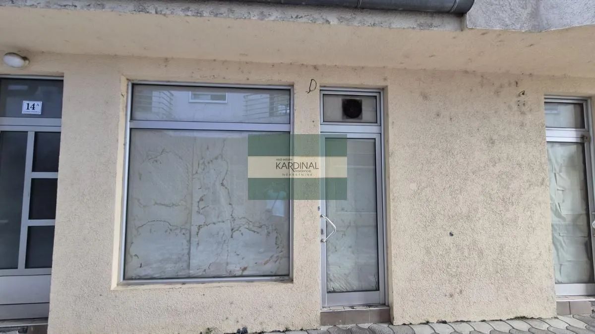 View of the exterior part of the building with an entrance door and display window.