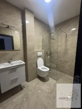 Moderno opremljeno kupatilo sa tuš kabinom i keramičkim pločicama u zemljanim tonovima. - image 9