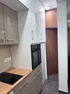 Modern kitchen with a built-in oven, hob, and upper cabinets. - image 9