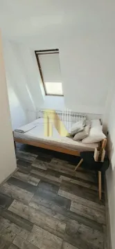 Manja spavaća soba u potkrovlju sa krevetom i krovnim prozorom. - image 6