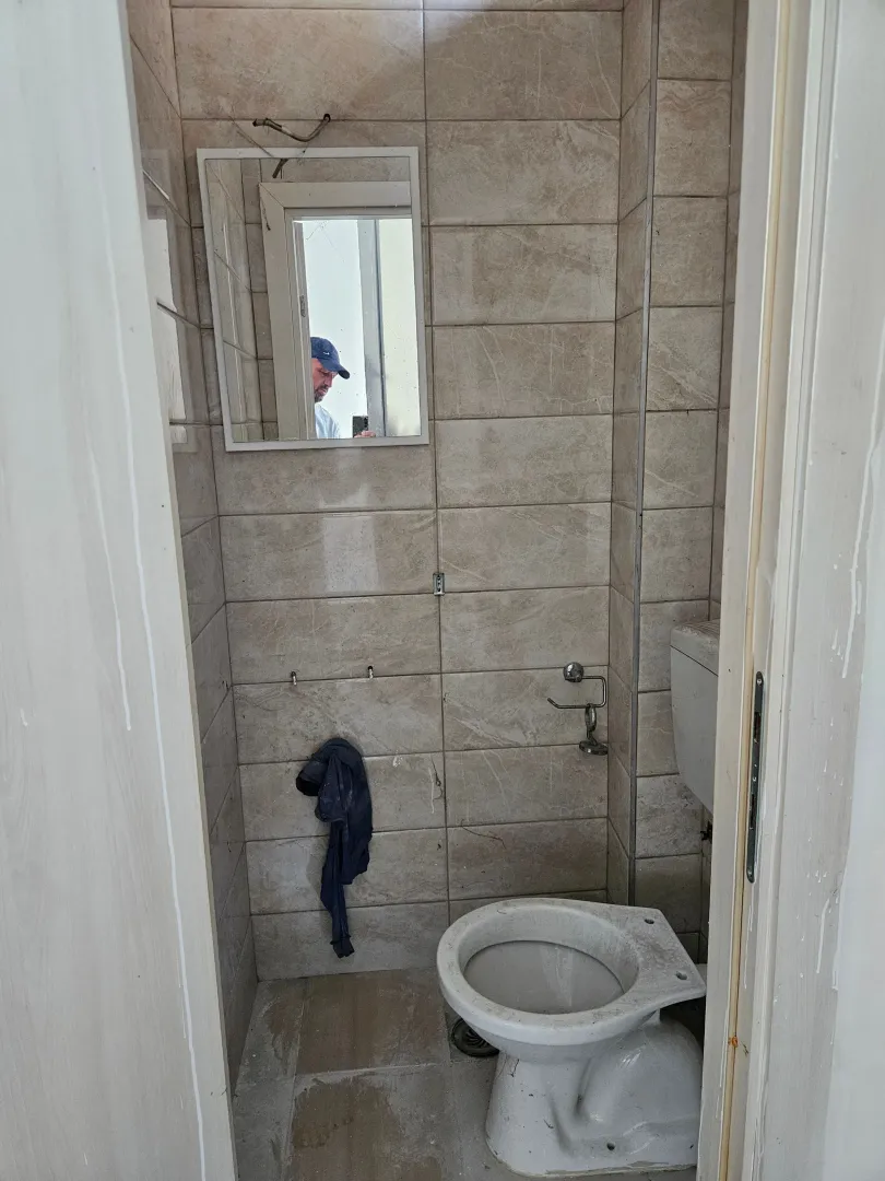 Small tiled bathroom with a toilet.