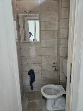 Small tiled bathroom with a toilet. - image 7