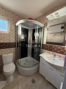 Bathroom equipped with a shower cabin, washbasin, and toilet. - image 11