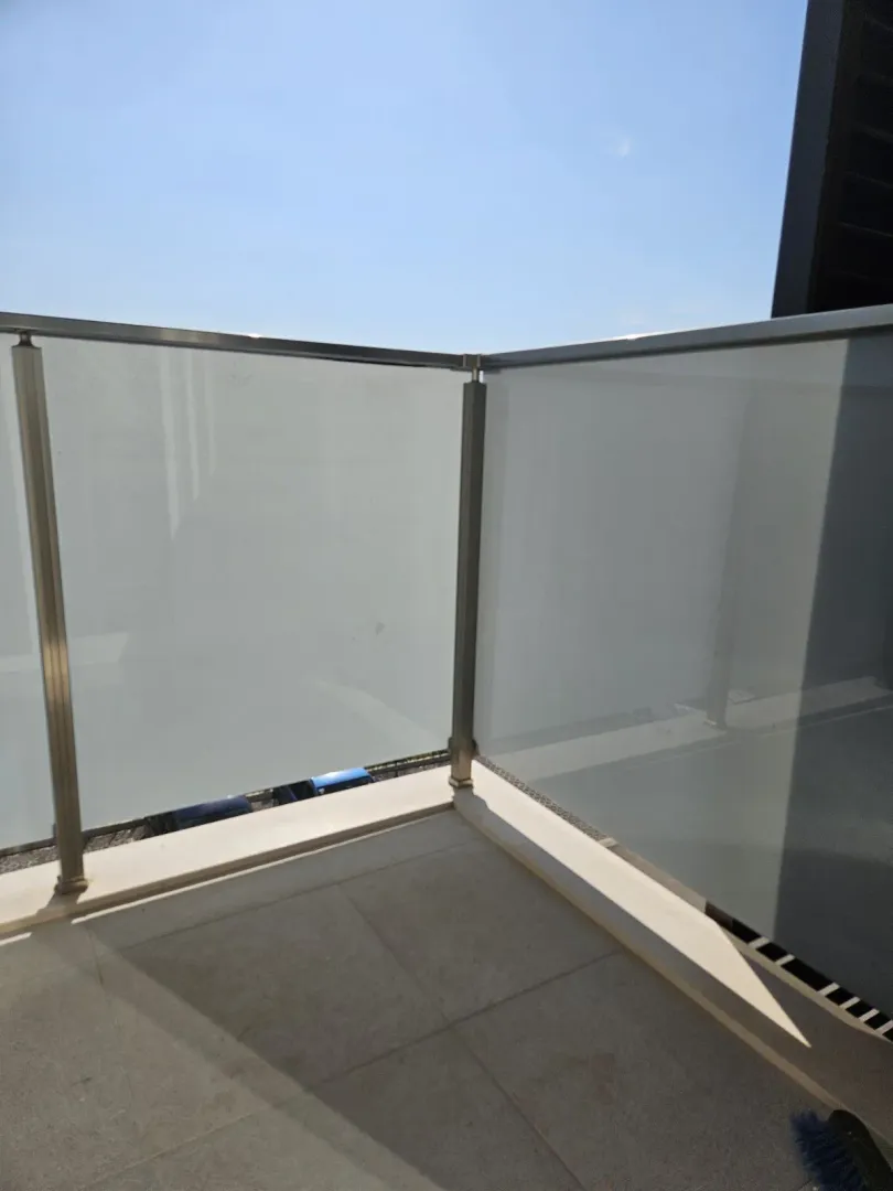 View of a terrace section with a modern glass railing.
