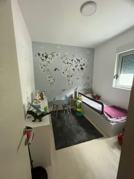 Children's bedroom with a bed, desk, and world map wall mural. - image 7